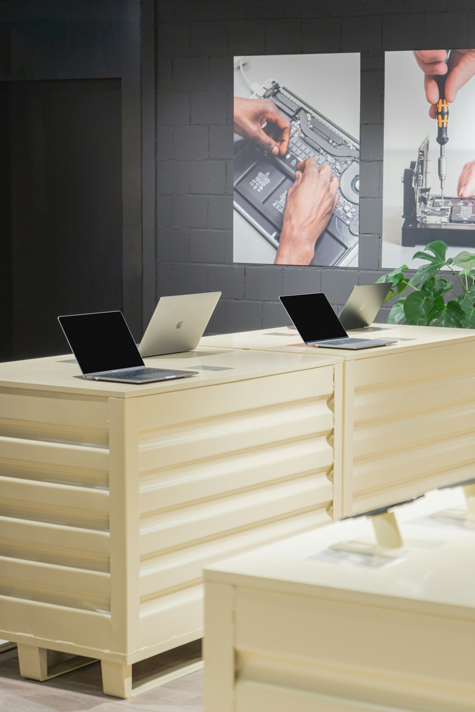 Tienda de tecnología moderna con portátiles expuestos en mesas metálicas.